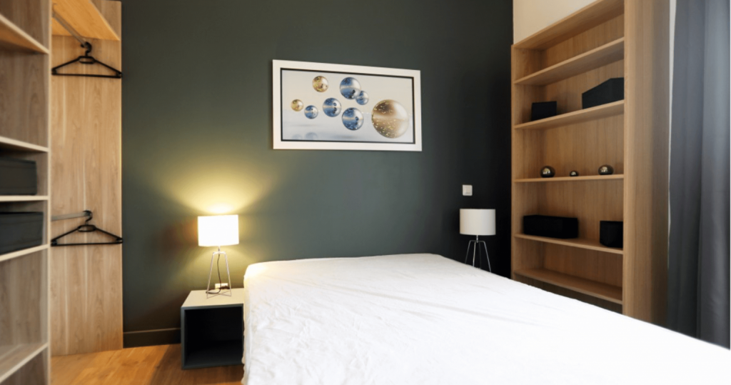 investissement locatif colocation- chambre mur vert foncé lit dressing lampe allumée