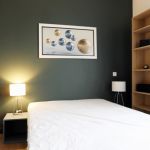 investissement locatif colocation- chambre mur vert foncé lit dressing lampe allumée