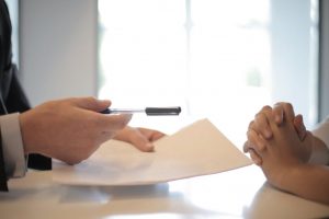 gestion de patrimoine nantes-homme qui tient un stylo dans sa main contrat