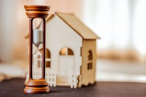 donation immobilière de son vivant-maquette de maison en bois-sablier